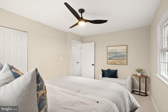 carpeted bedroom with ceiling fan and baseboards