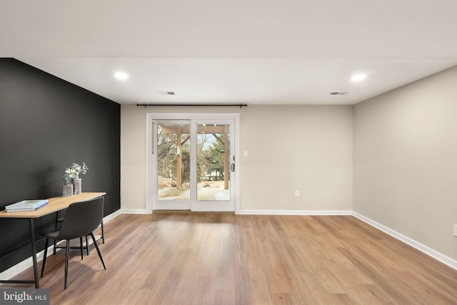 interior space featuring light wood-style flooring, visible vents, and baseboards