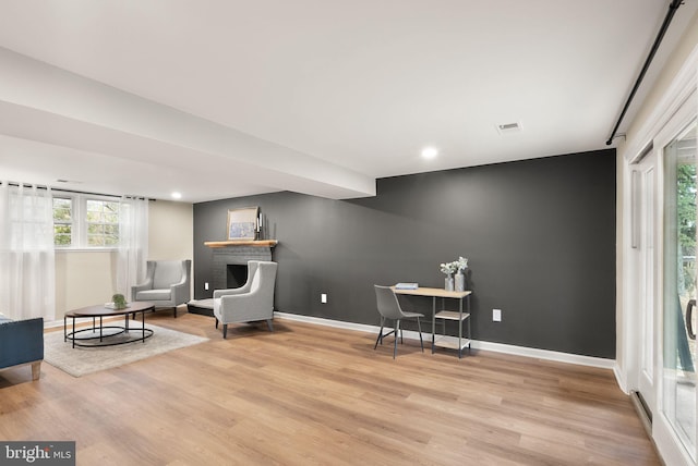 sitting room with recessed lighting, visible vents, an accent wall, wood finished floors, and baseboards