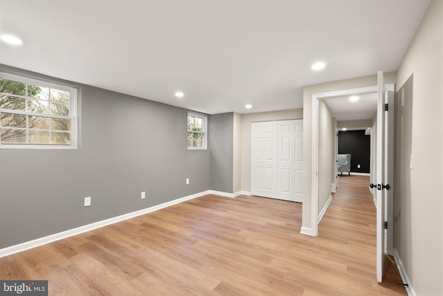 unfurnished bedroom with baseboards, a closet, recessed lighting, and light wood-style floors