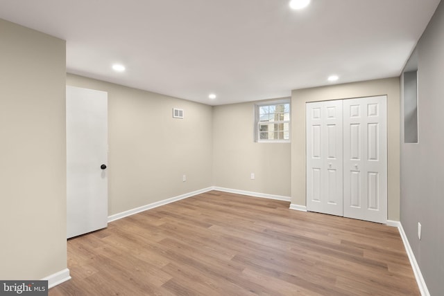 basement with recessed lighting, light wood-type flooring, visible vents, and baseboards