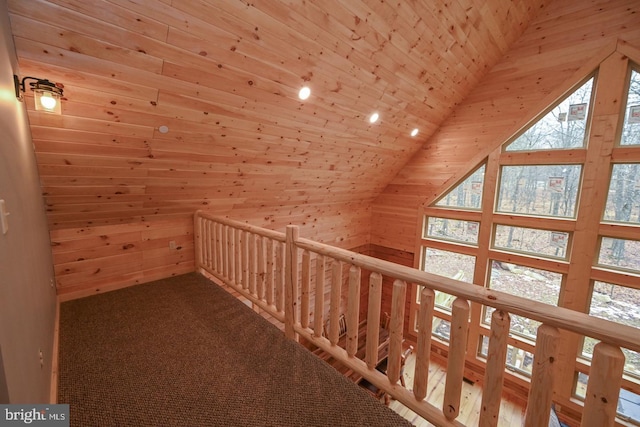 corridor with carpet, vaulted ceiling, wooden ceiling, and wood walls