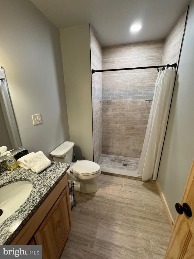 bathroom with a shower with shower curtain, vanity, and toilet