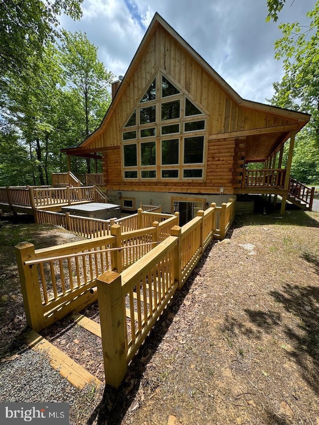 rear view of house featuring a wooden deck