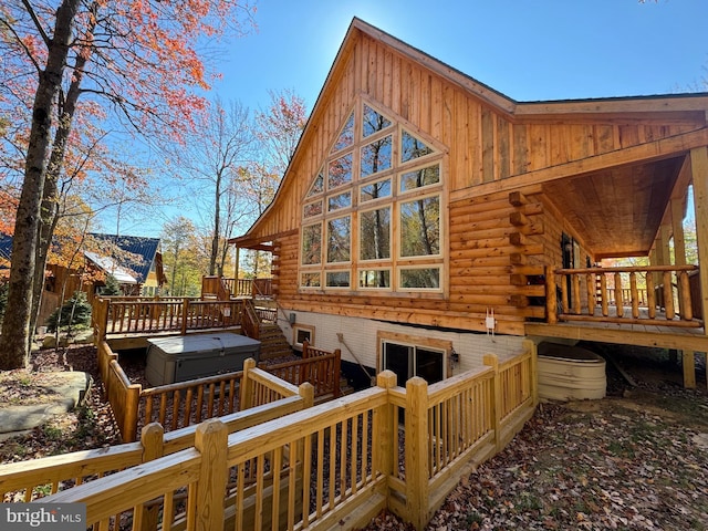 back of property with a covered hot tub