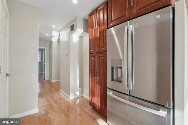 kitchen with stainless steel fridge with ice dispenser and light hardwood / wood-style floors