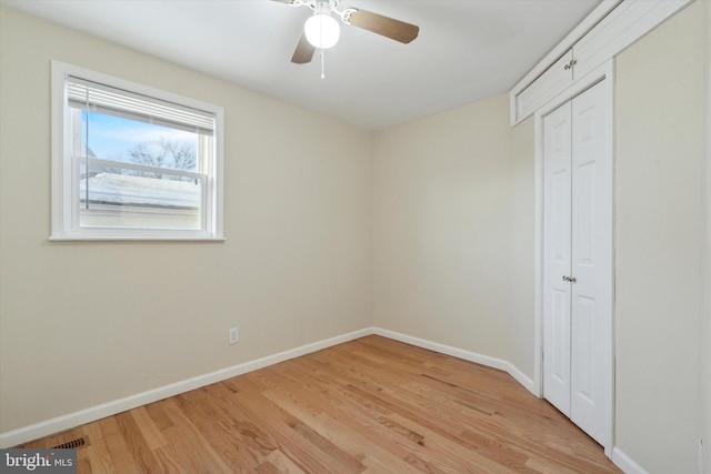 unfurnished bedroom with a closet, light hardwood / wood-style flooring, and ceiling fan