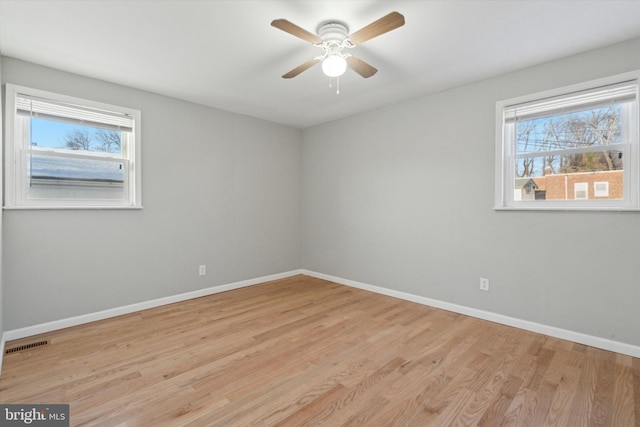 unfurnished room with light hardwood / wood-style floors, a wealth of natural light, and ceiling fan