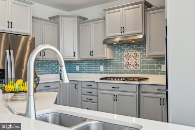 kitchen with stainless steel appliances, gray cabinets, and backsplash