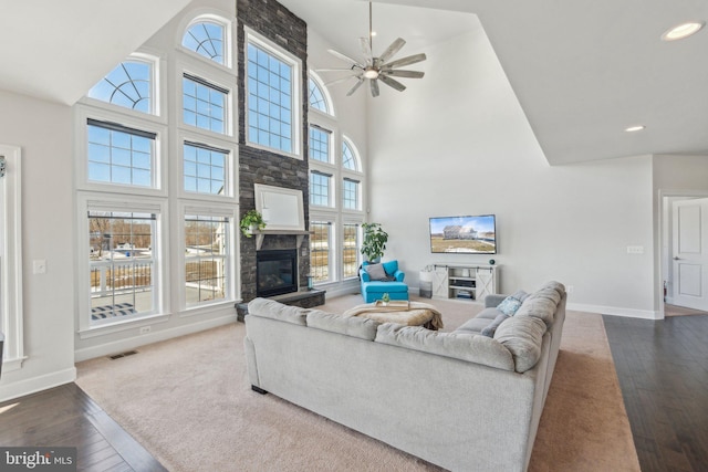 living room featuring a high ceiling, wood-type flooring, and ceiling fan