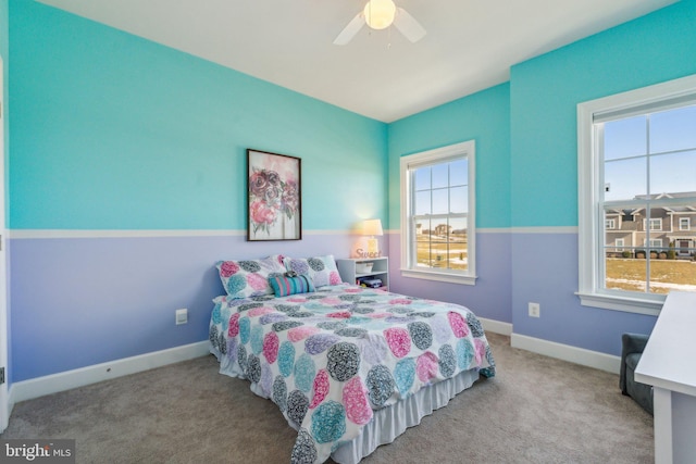 carpeted bedroom featuring ceiling fan and multiple windows