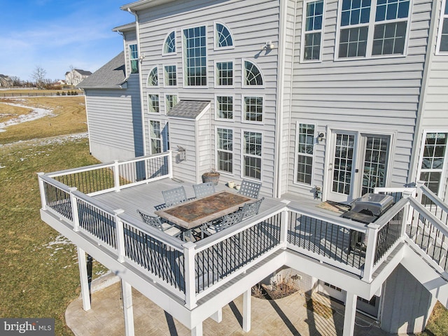 rear view of house featuring a patio area, a deck, and a lawn