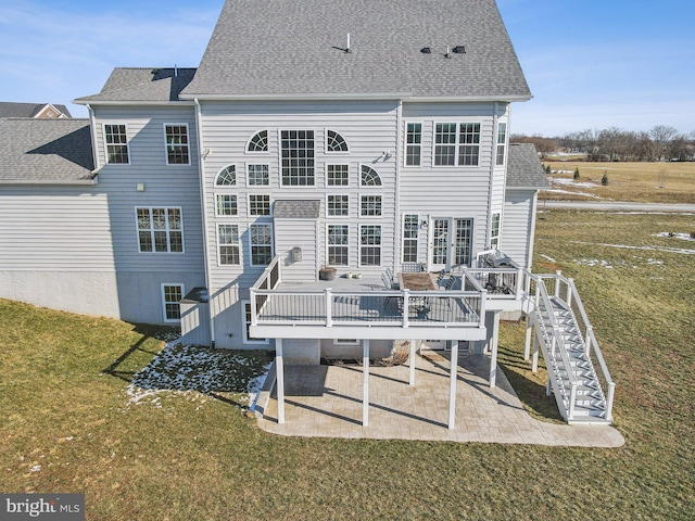 back of property with a wooden deck, a lawn, and a patio area