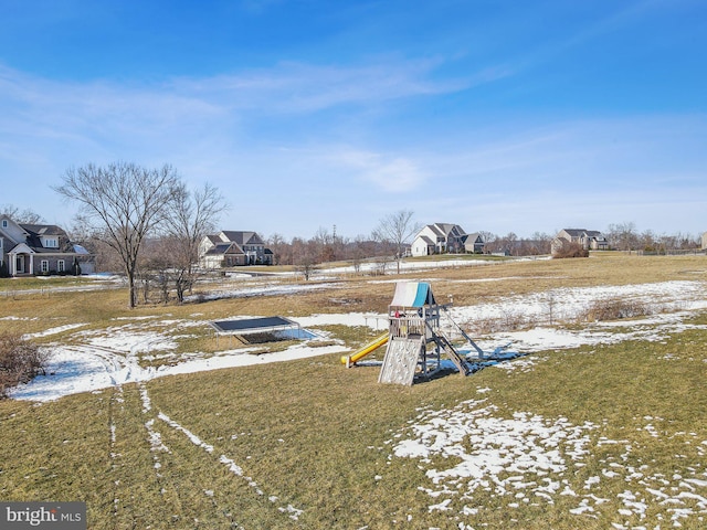 yard covered in snow with a playground