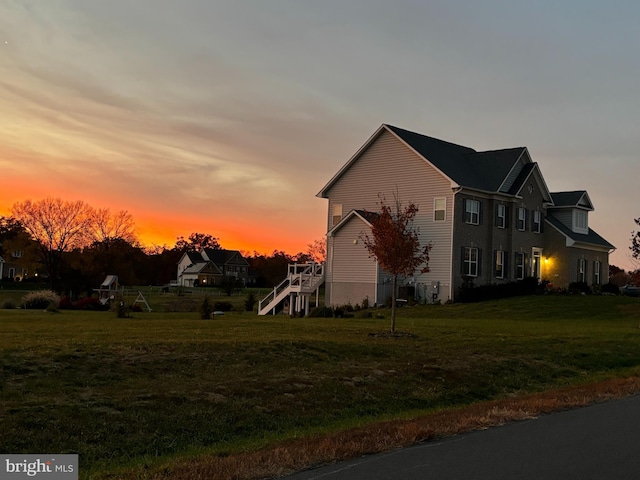 property exterior at dusk featuring a yard