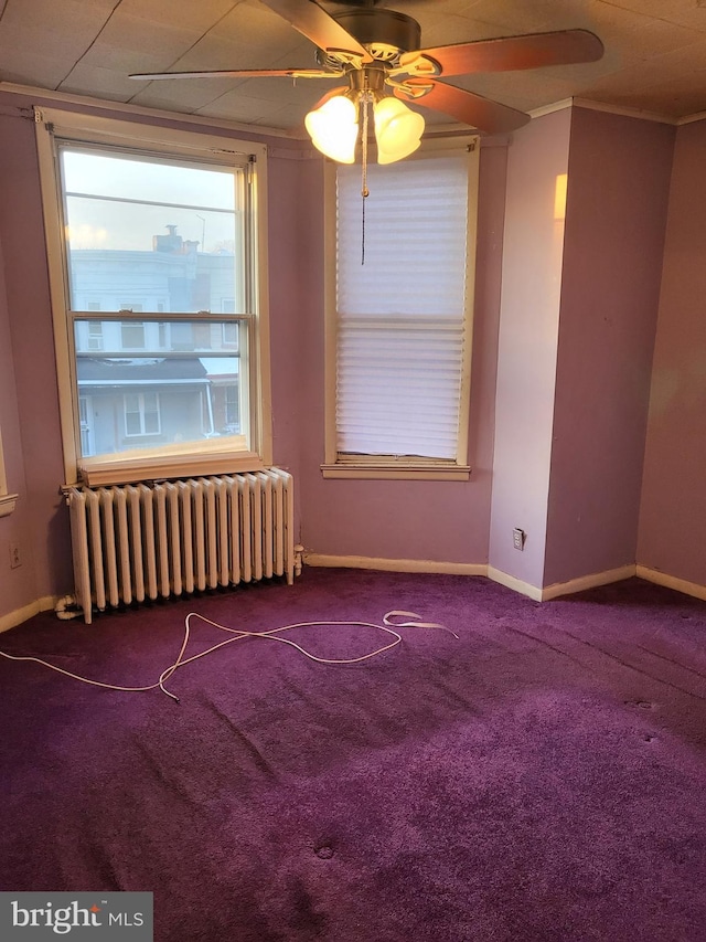 spare room featuring carpet, ceiling fan, crown molding, and radiator