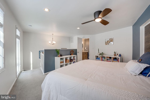 carpeted bedroom featuring ceiling fan with notable chandelier