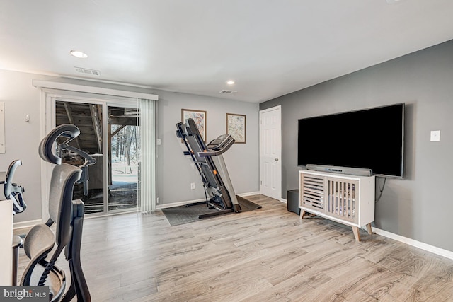 exercise room with light hardwood / wood-style floors