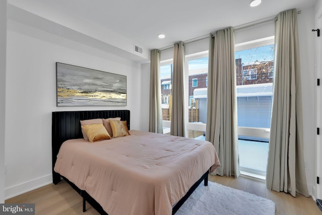 bedroom with access to exterior and light hardwood / wood-style flooring