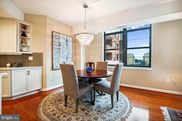 dining space with dark hardwood / wood-style flooring and a notable chandelier