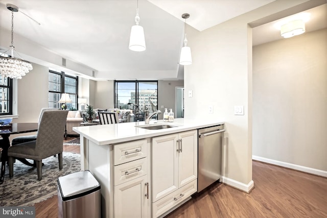 kitchen with kitchen peninsula, sink, and hanging light fixtures