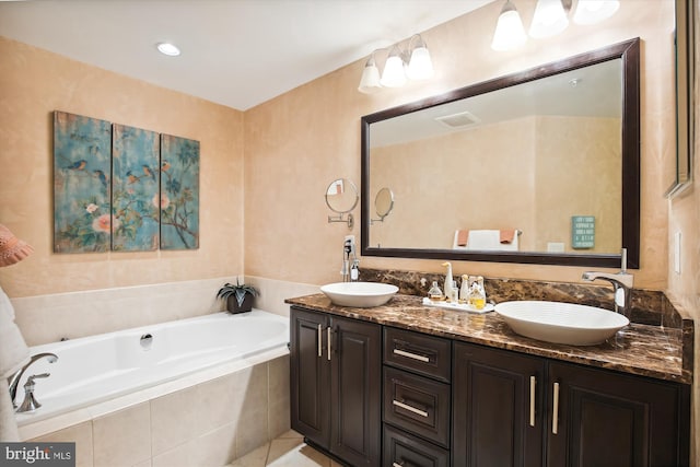 bathroom with vanity and tiled tub