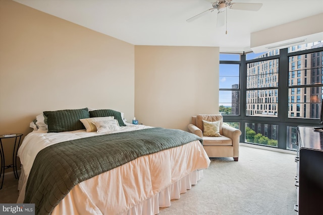 carpeted bedroom with ceiling fan and a wall of windows