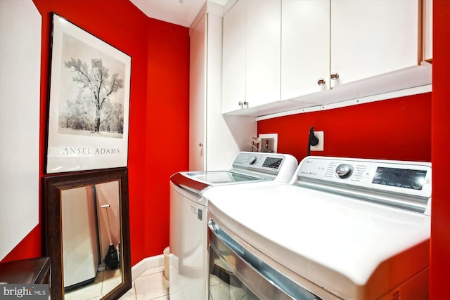 laundry area with cabinets, washer and clothes dryer, and light tile patterned flooring