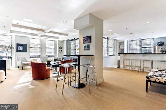 interior space featuring a kitchen bar, light carpet, refrigerator, and coffered ceiling