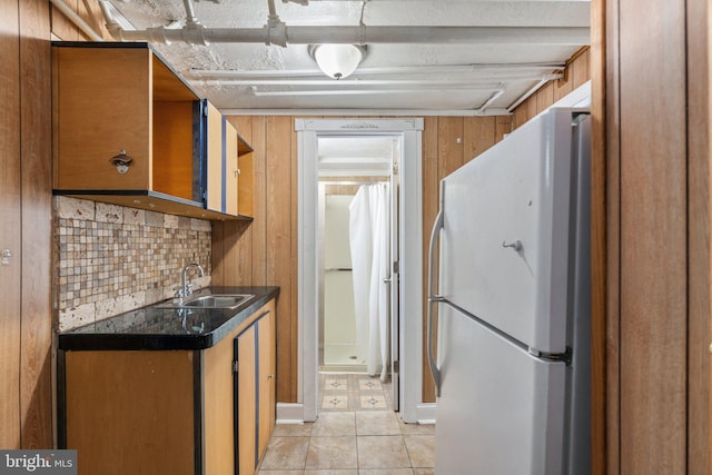 kitchen with tasteful backsplash, sink, white fridge, and light tile patterned flooring