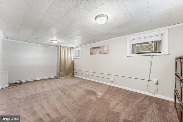 basement with carpet, crown molding, and a wall mounted AC