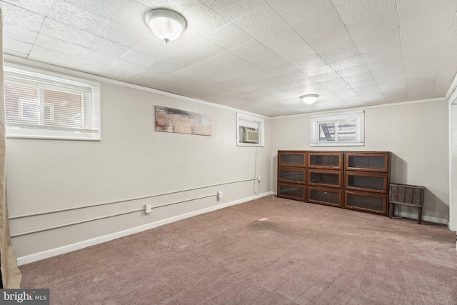 basement with carpet floors, a wall unit AC, and crown molding