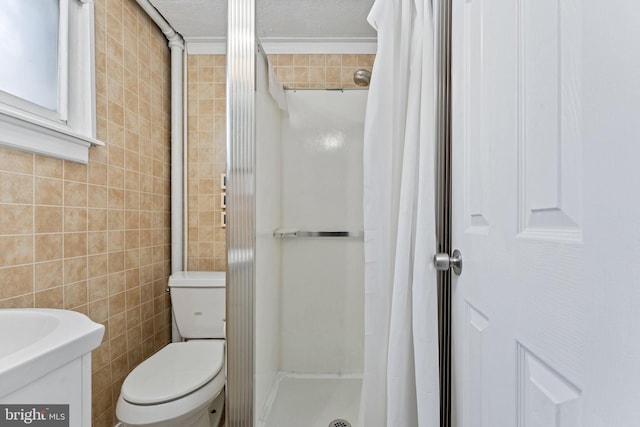 bathroom featuring curtained shower, toilet, ornamental molding, and tile walls