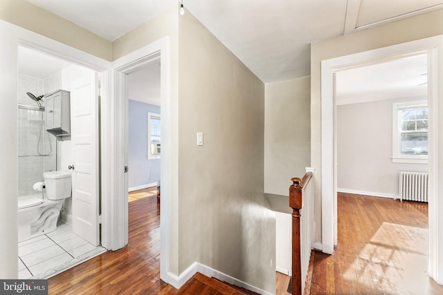 corridor featuring radiator heating unit and hardwood / wood-style flooring