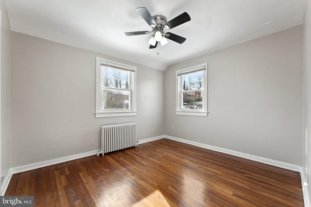 unfurnished room with radiator, ceiling fan, and dark hardwood / wood-style floors