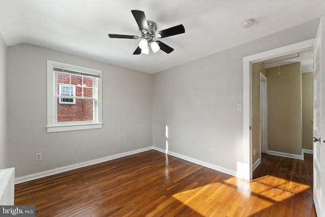 empty room with dark hardwood / wood-style flooring, ceiling fan, and lofted ceiling