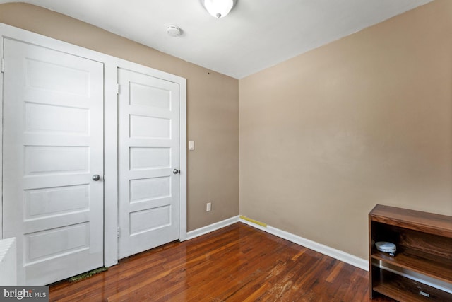 unfurnished bedroom with dark hardwood / wood-style floors