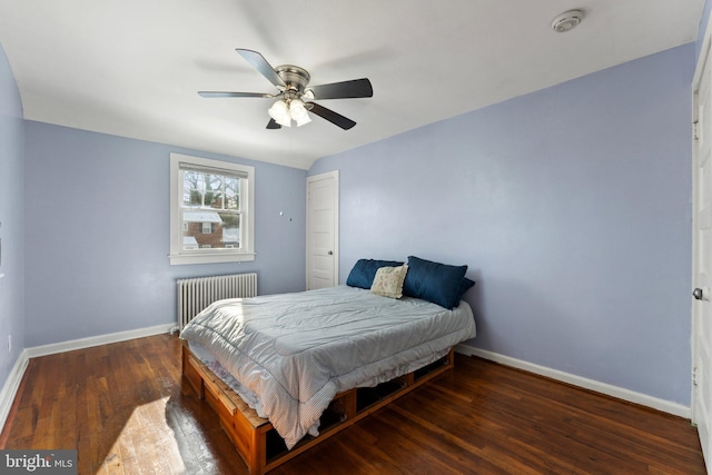 bedroom with ceiling fan, radiator heating unit, and dark wood-type flooring