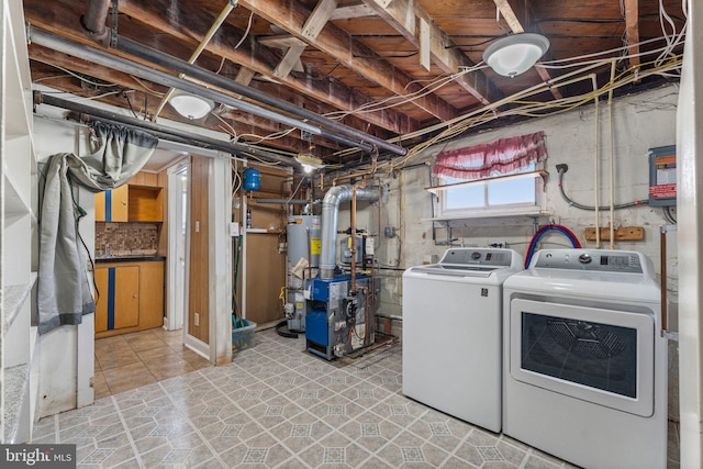 laundry room with washing machine and dryer, light tile patterned floors, and gas water heater