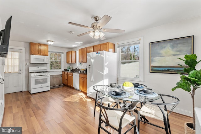 kitchen with white appliances, light hardwood / wood-style flooring, ceiling fan, and sink