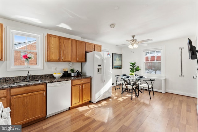 kitchen featuring sink, a healthy amount of sunlight, white appliances, and light wood-type flooring