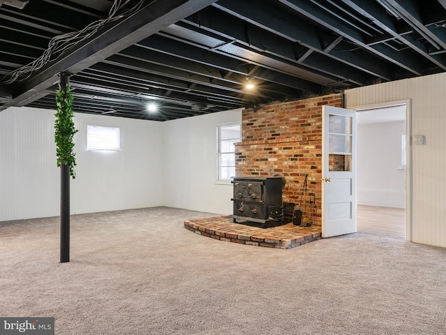 basement with carpet floors and a wood stove