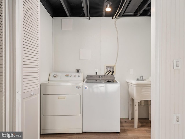 laundry room with washer and clothes dryer and hardwood / wood-style floors