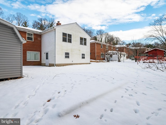 view of snow covered rear of property