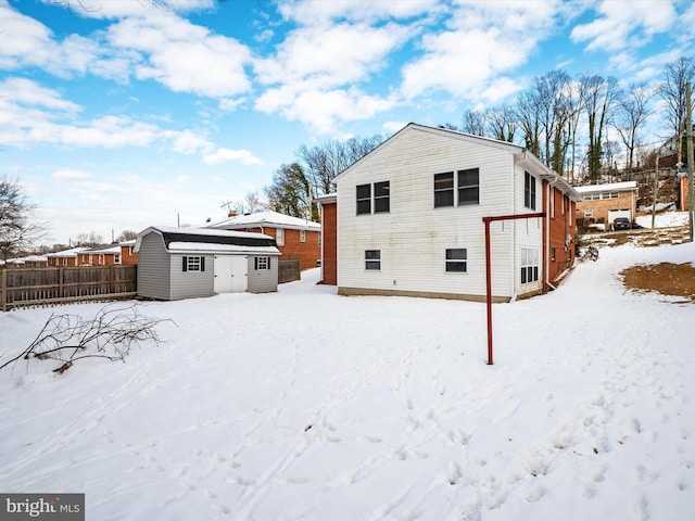 snow covered house with a storage shed