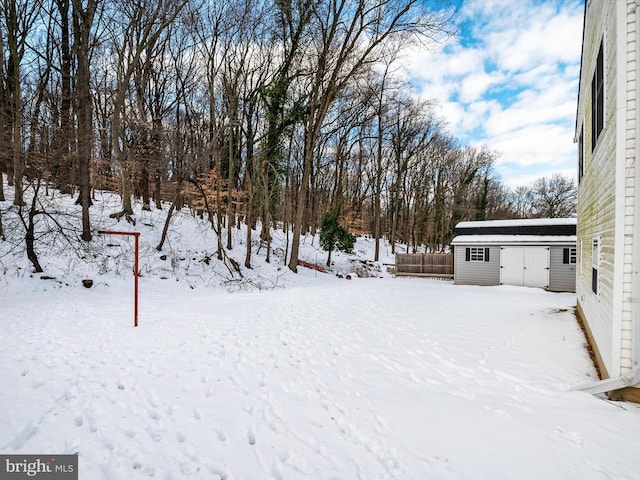 yard covered in snow with a storage shed