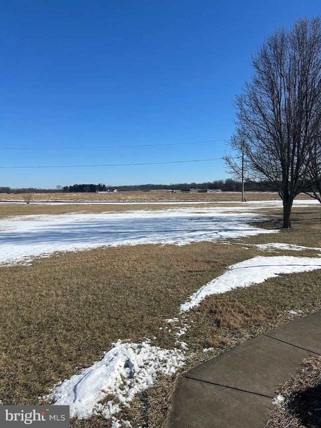 snowy yard featuring a rural view