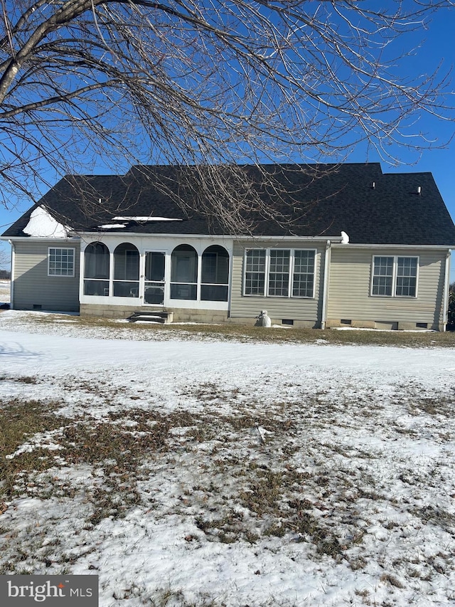 snow covered house with a sunroom