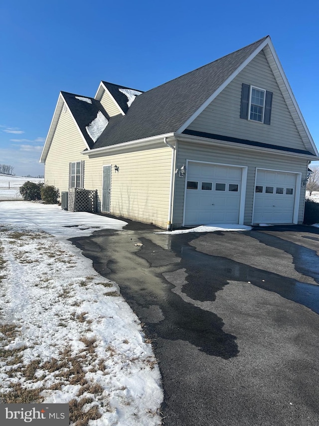 view of snow covered exterior featuring a garage