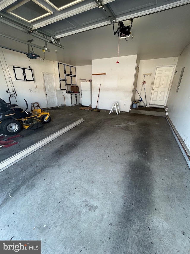 garage with white refrigerator and a garage door opener